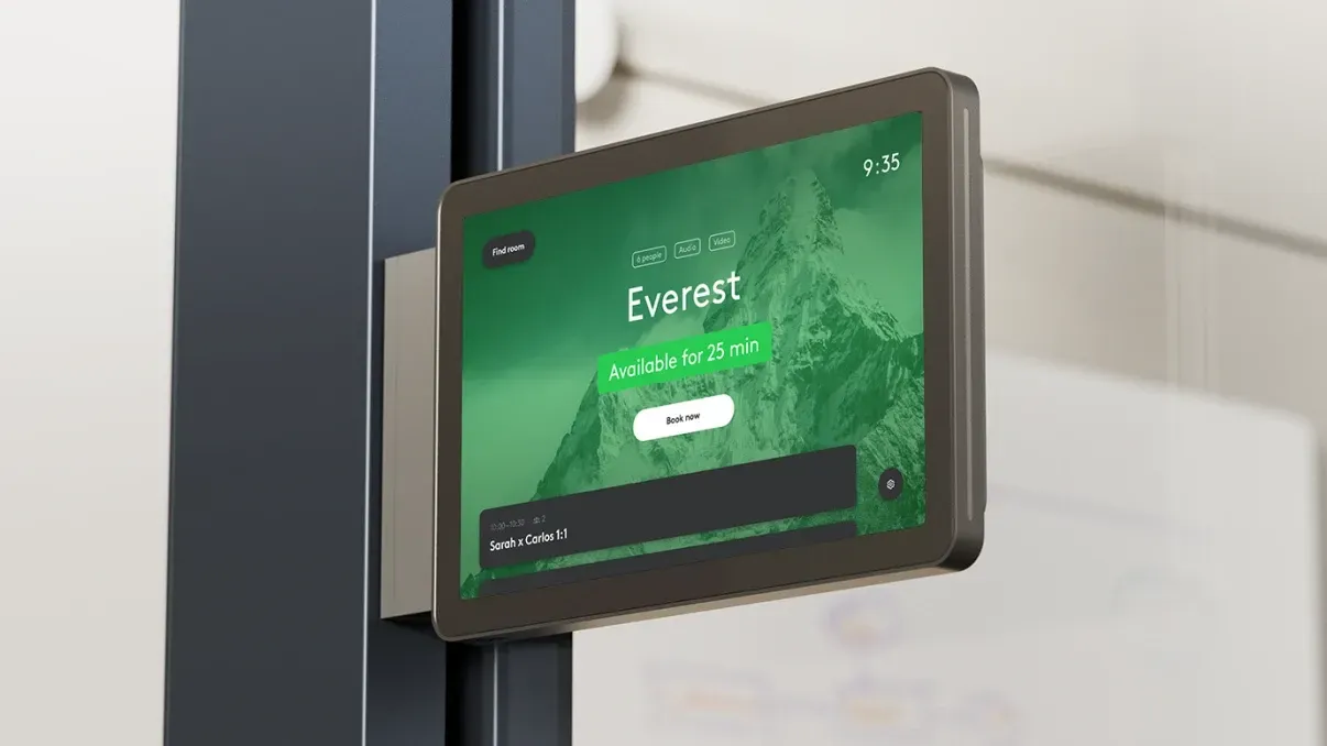 A tablet with a green screen is hanging on a wall.