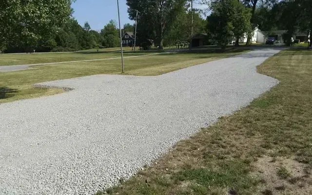 A freshly installed gravel driveway leading up to a residential property.