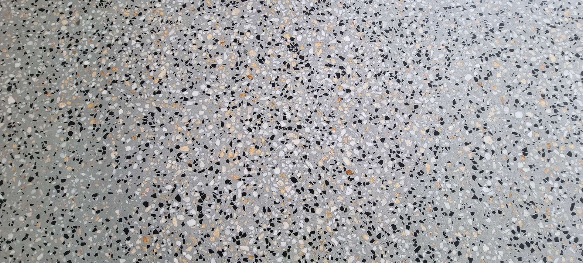Close-up of a speckled gray terrazzo surface with black, white, and beige flecks