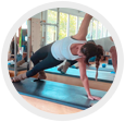 Two people doing a plank workout on yoga mats in a studio