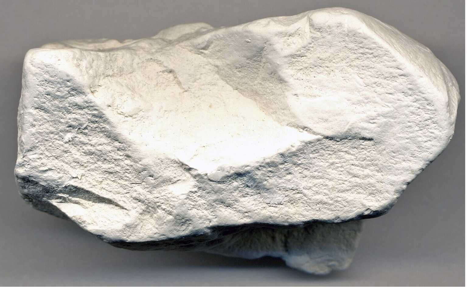 Roca blanca, de forma irregular y superficie rugosa.