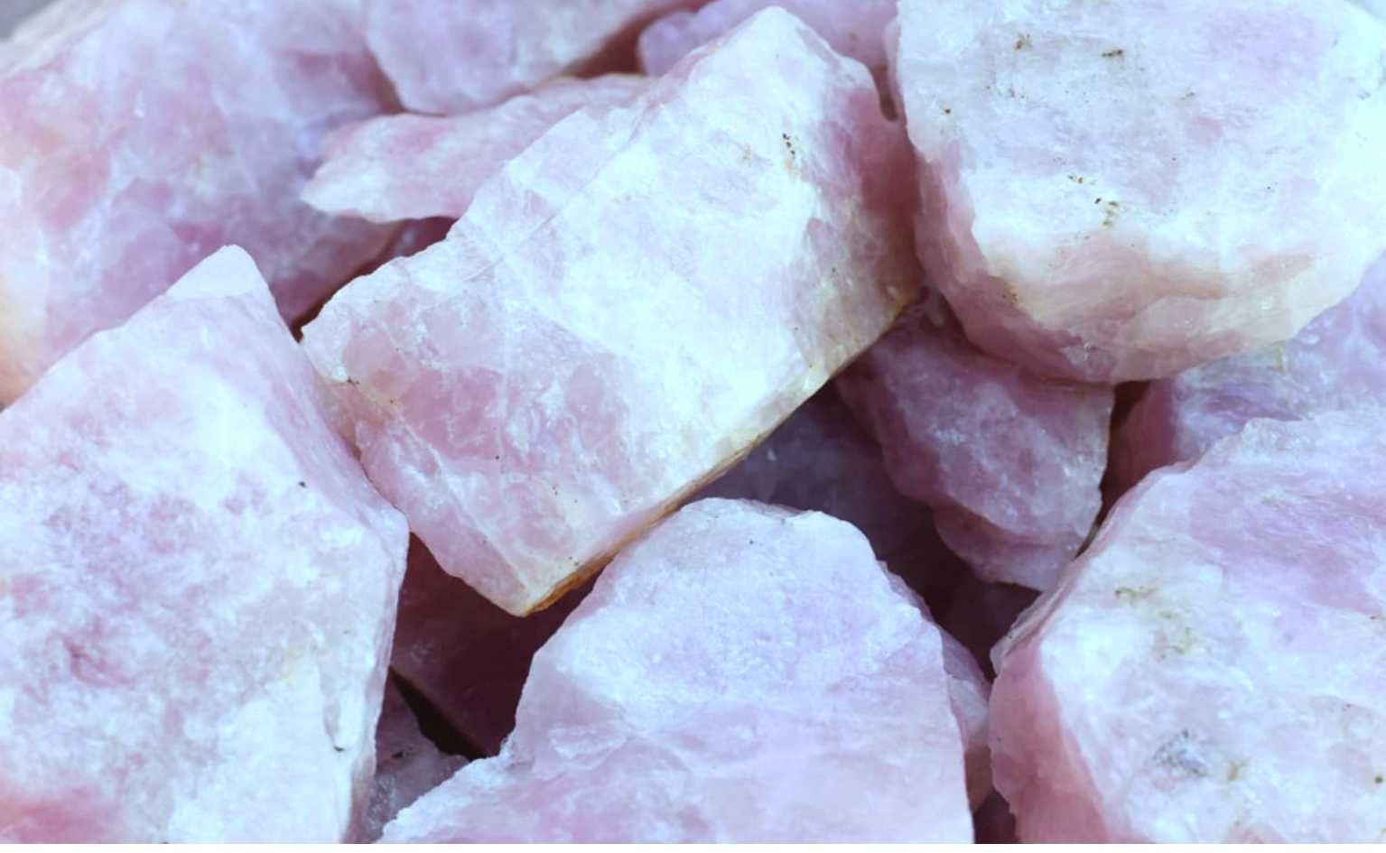 Montón de cristales de cuarzo rosa, ásperos y de color rosa claro.