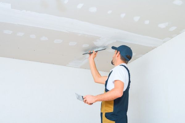 Drywall contractor applying joint compound to a ceiling with expert craftsmanship from Anaheim Drywall Contractor