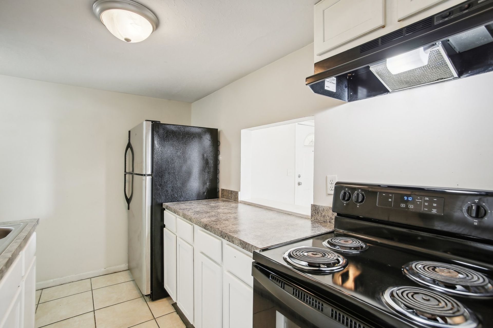 Kitchen with white cabinets, black appliances, and granite countertops.