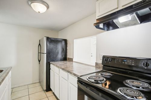 Renovated Kitchen Slide 1 caption: Updated cabinets, dark countertops, and black appliances