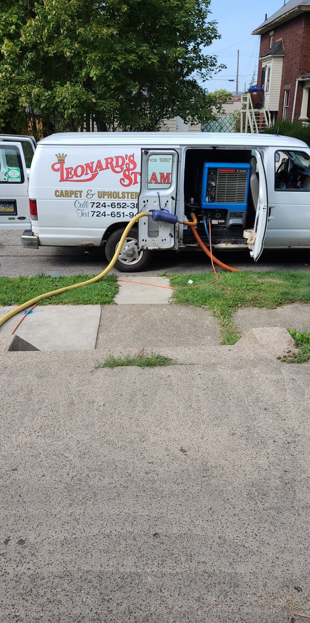 A yellow vacuum cleaner cleans a gray carpet, showing a clear contrast between the dirty and clean areas.