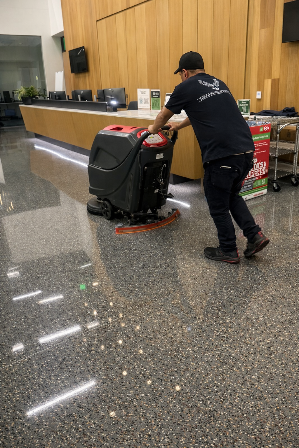 Eagle Maintenance crew member operating a commercial floor scrubber at a conference center lobby
