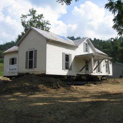 A white house is being moved to a new location
