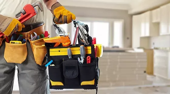 A man is carrying a toolbox full of tools.