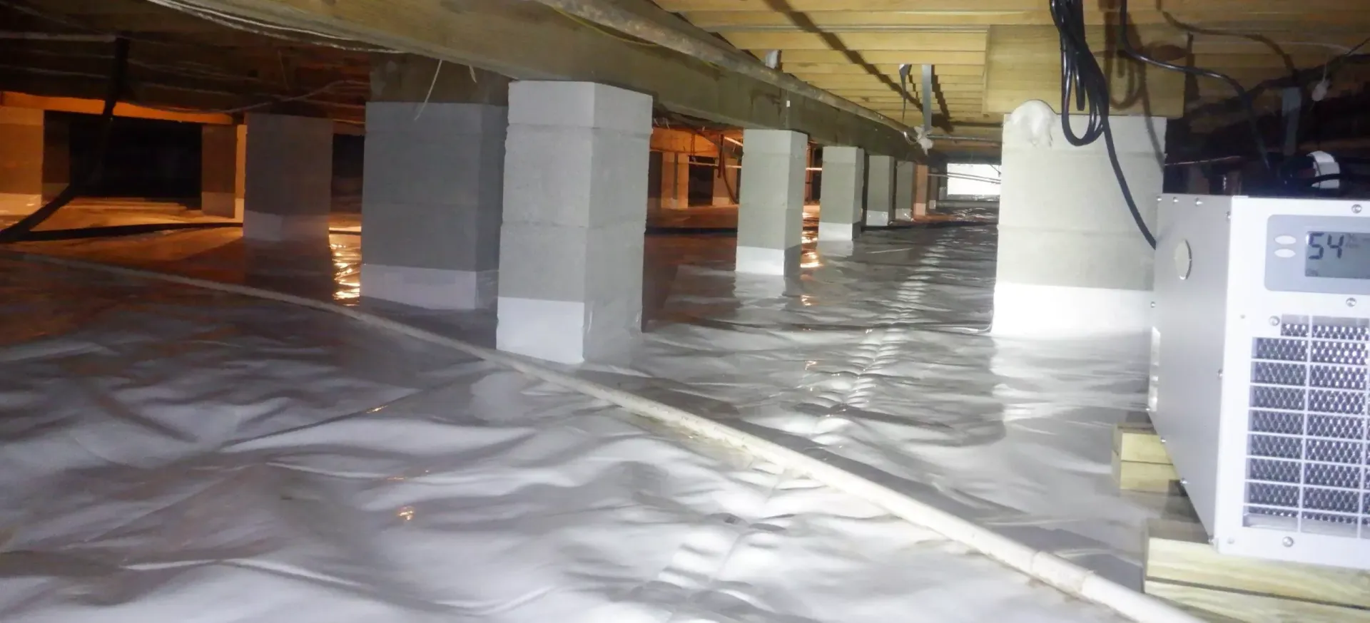A flooded basement with a machine in the middle of it.