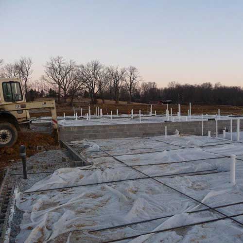 A bulldozer is parked on a construction site covered in plastic.