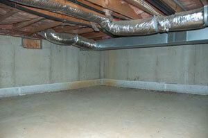An empty basement with a lot of pipes coming out of the ceiling.