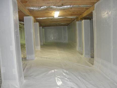 A basement filled with plastic and wooden beams.