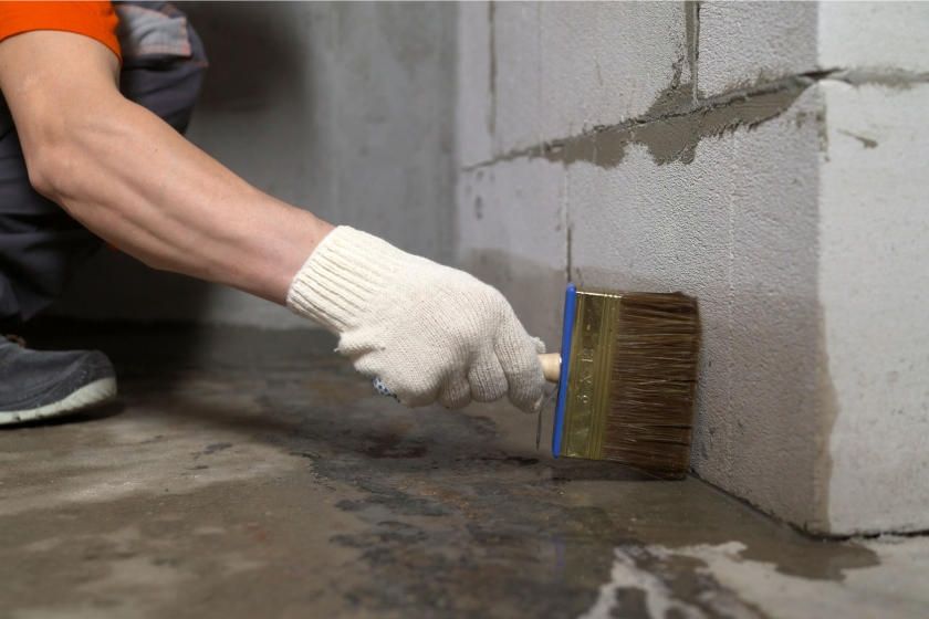 A person is painting a wall with a brush.