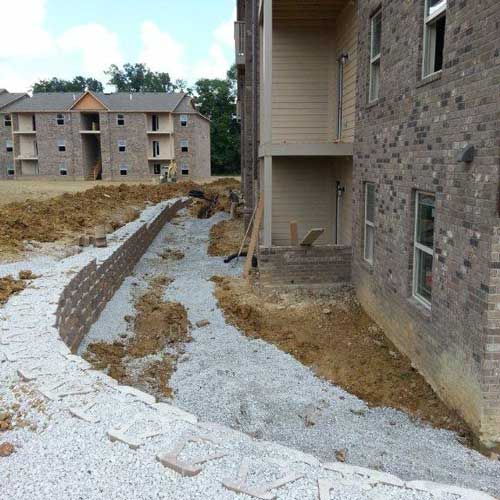 A brick building with a walkway leading to it is under construction.