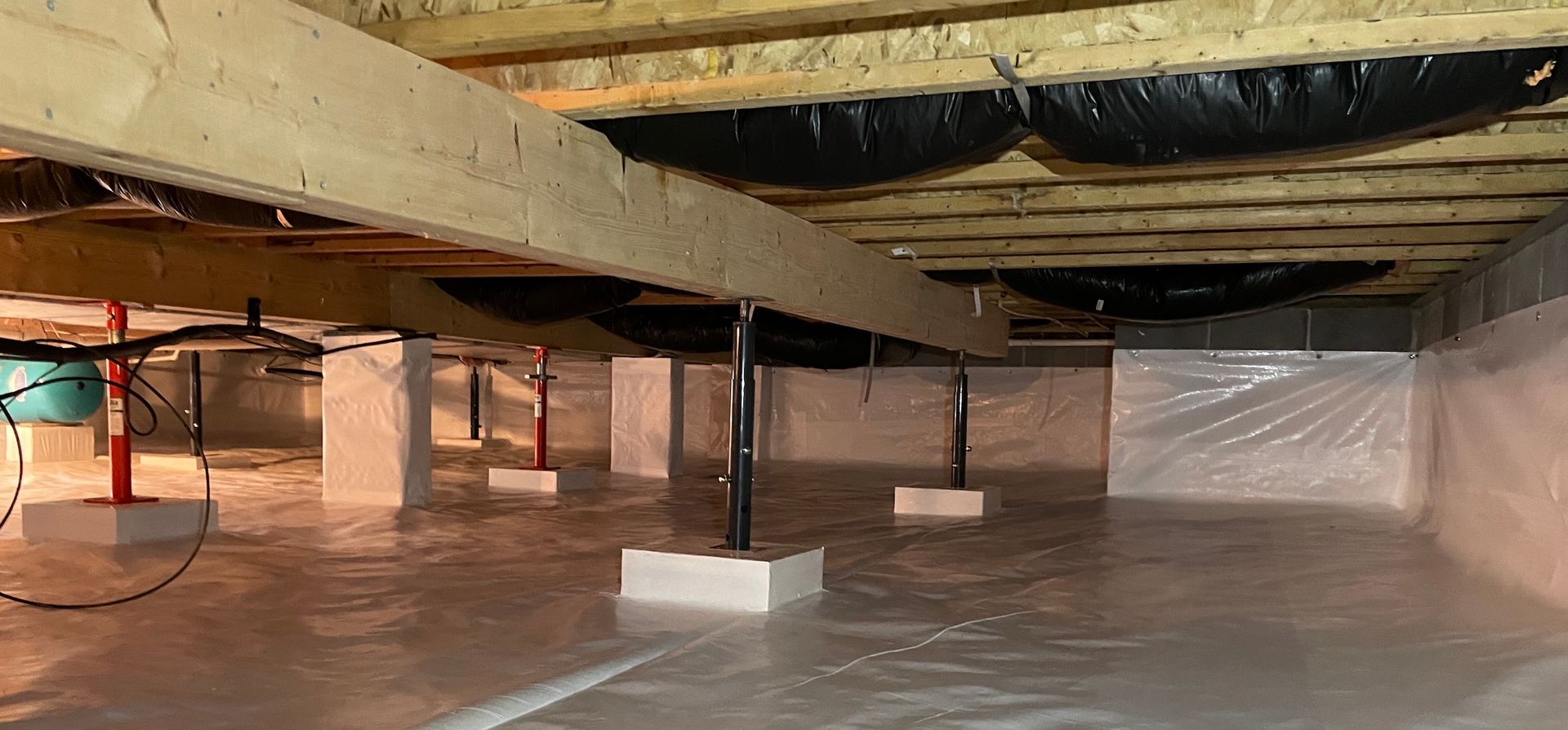 A basement filled with plastic and wooden beams.