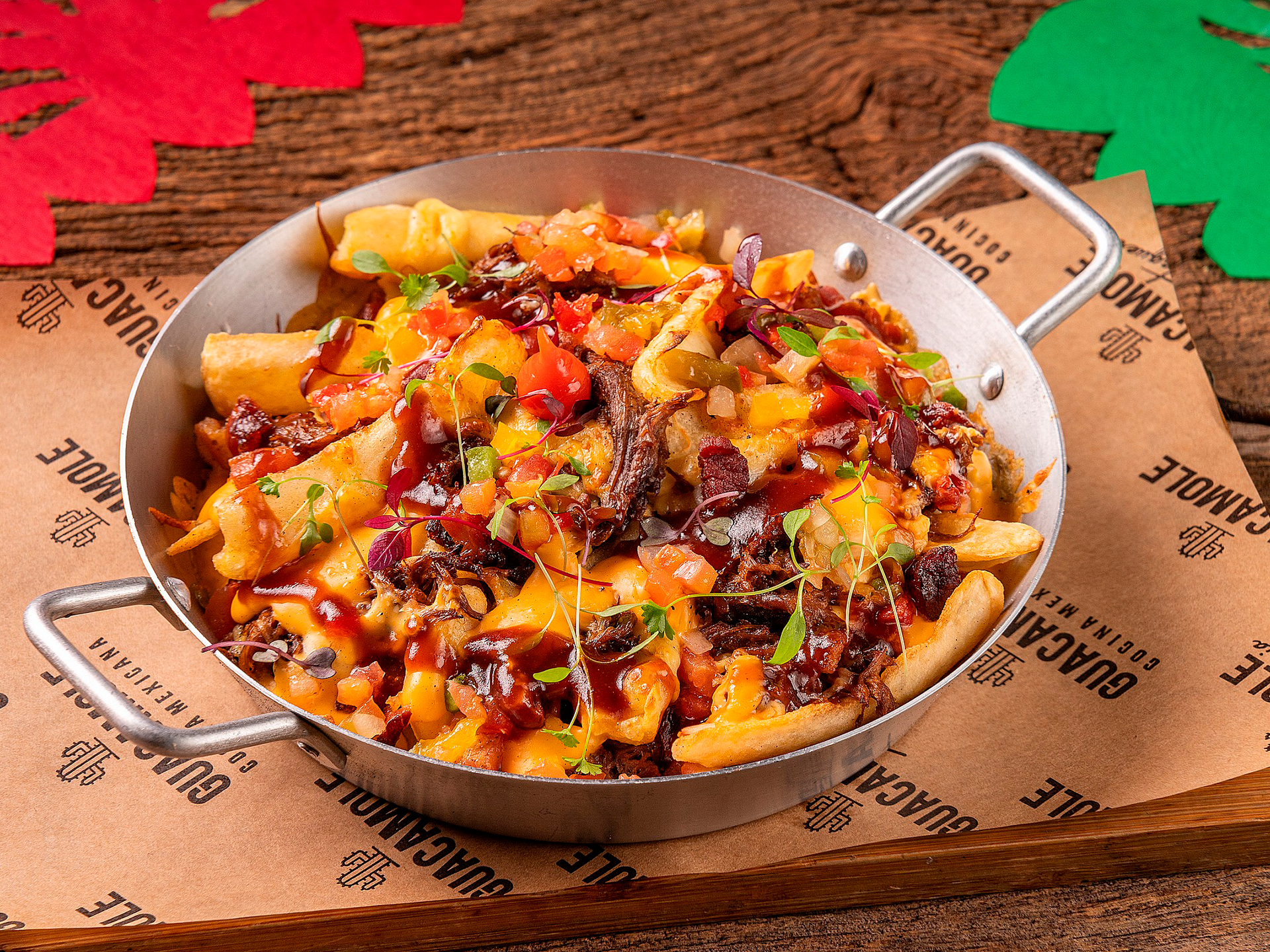 Bandeja de nachos com queijo e molho, cobertos com salsa, servidos em papel pardo sobre uma bandeja de madeira.