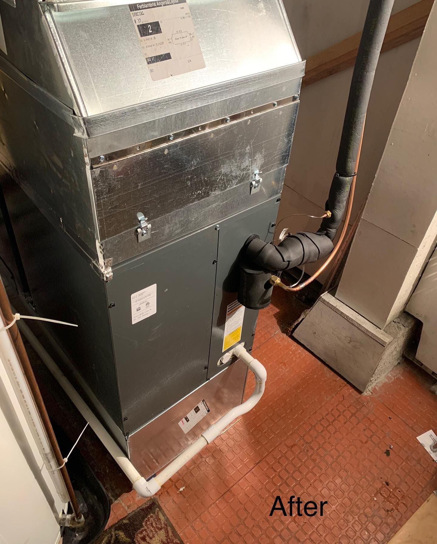 An air conditioner is sitting on a tiled floor in a room.