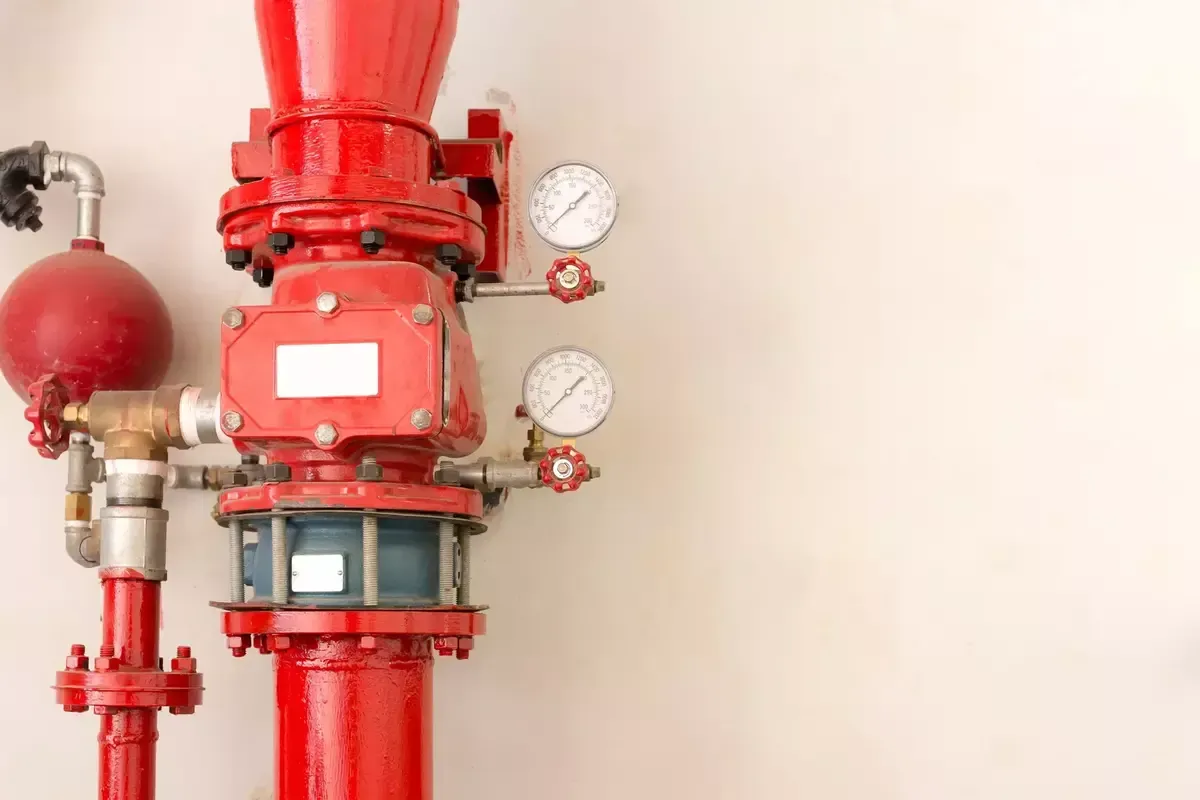 A red fire hydrant with two gauges attached to it.