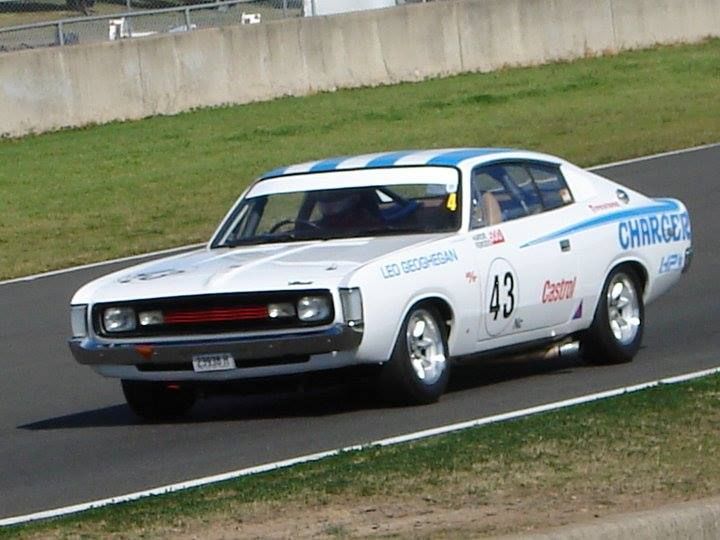 White race car number 43 speeding on a track, with blue and red sponsor decals