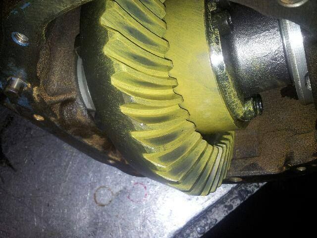 Mechanic working on an engine camshaft with a wrench in a close-up metal assembly