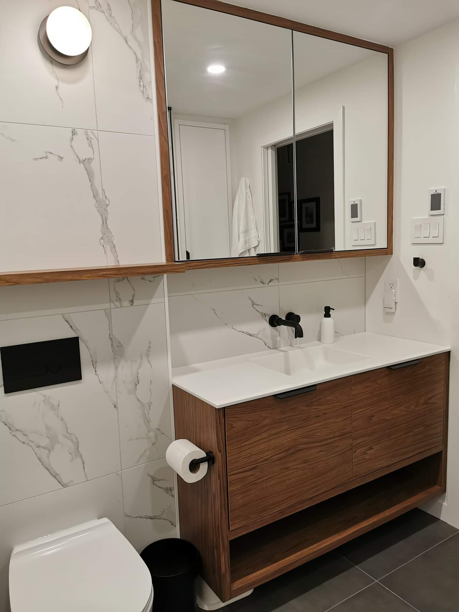 Une salle de bain avec lavabo , WC et miroir.