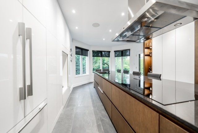 A kitchen with white cabinets and a black counter top