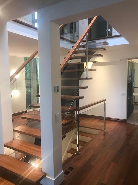 Un escalier avec des marches en bois et une rampe en verre