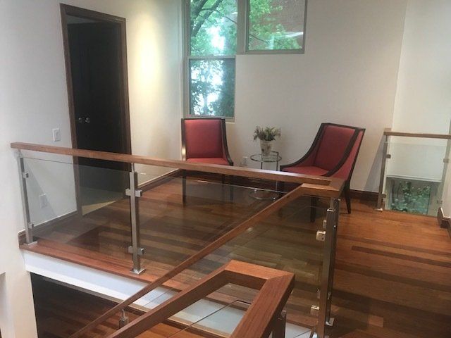 Un salon avec deux chaises et une balustrade en verre
