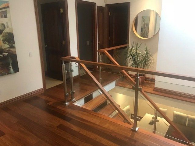 Un escalier en bois avec une rampe en verre dans une maison