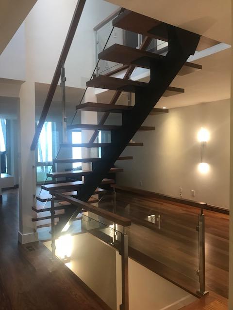 Un escalier avec des marches en bois et une rampe en verre