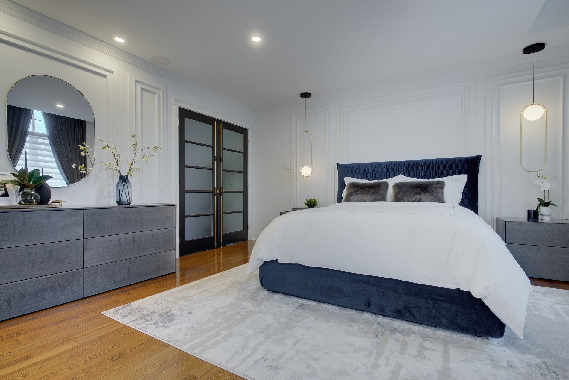 Une chambre avec un lit , une commode , une table de nuit et un miroir.
