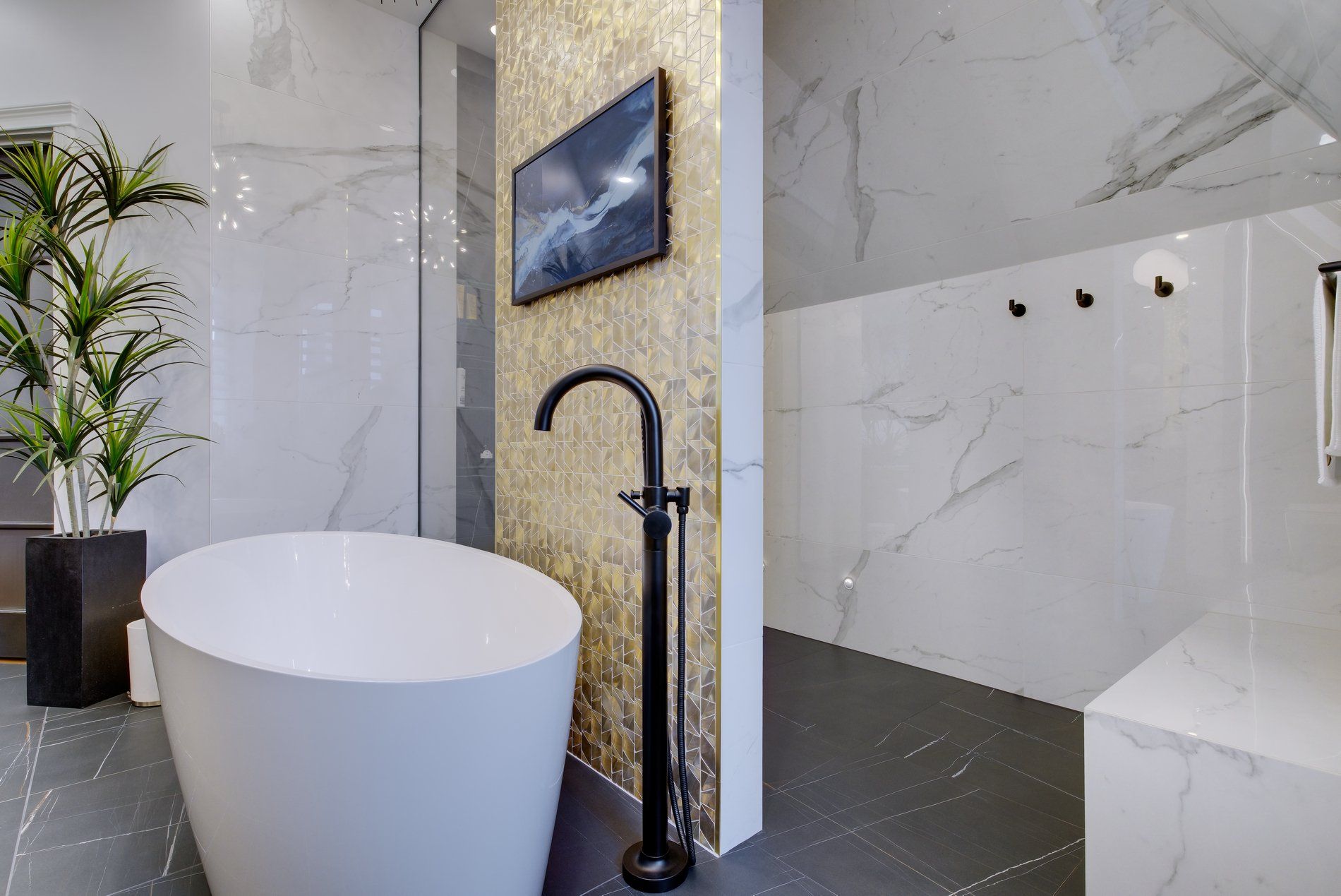 Une salle de bain avec baignoire et télévision au mur.