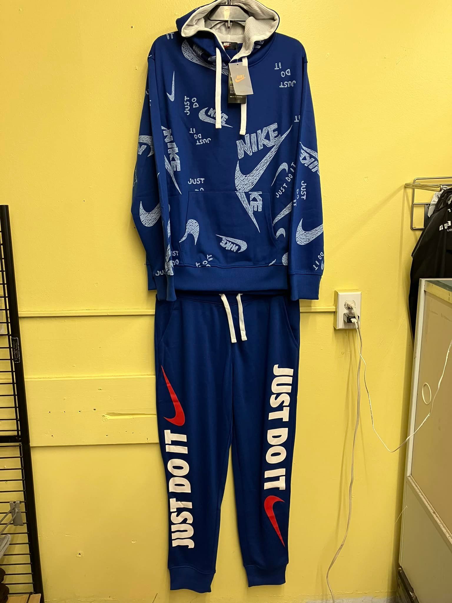 A blue Nike hooded sweatshirt and matching sweatpants set with white 