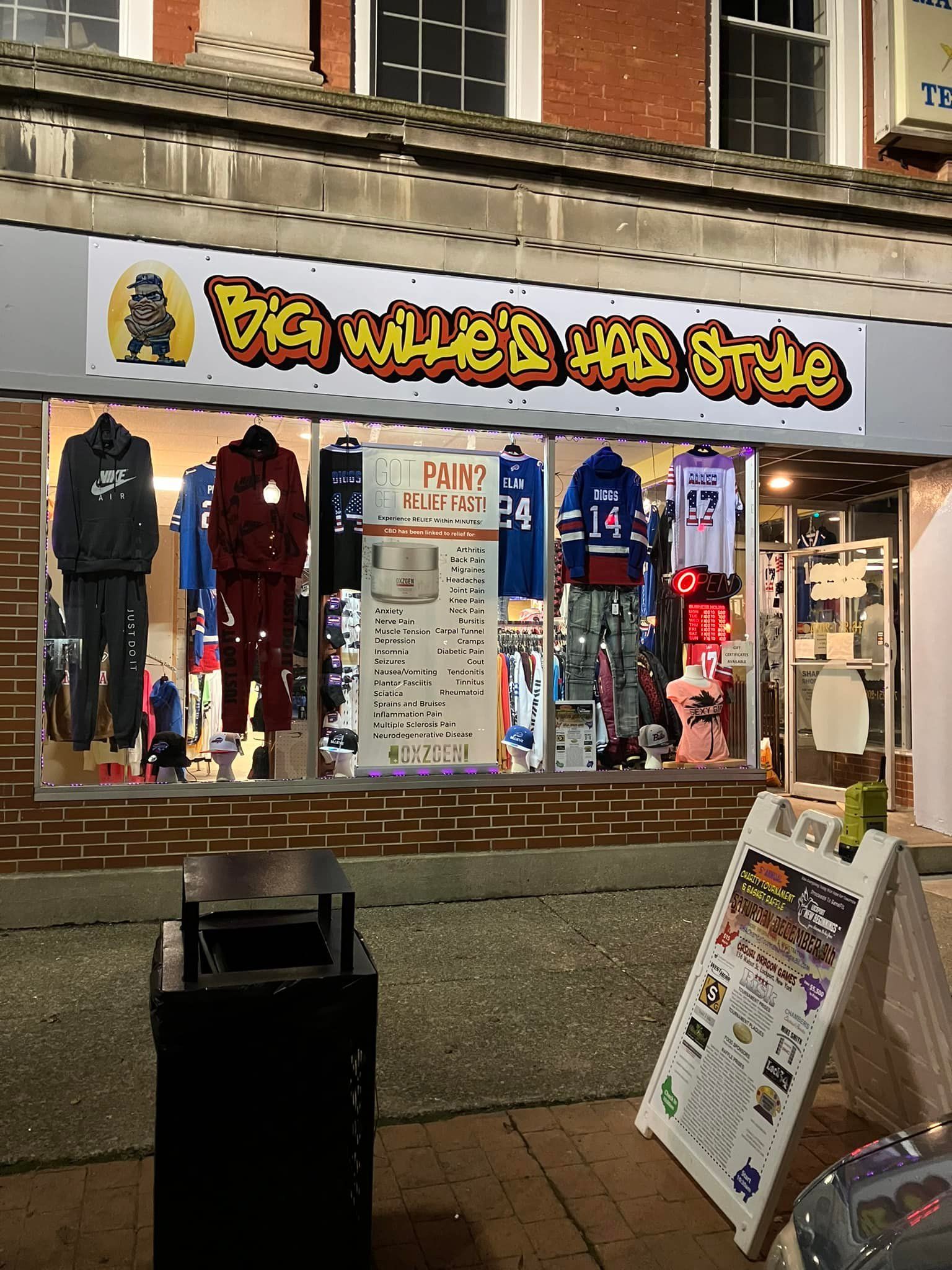 Storefront for Big Wille's Hip Style clothing store, featuring apparel displayed in large windows under a neon-style sign.