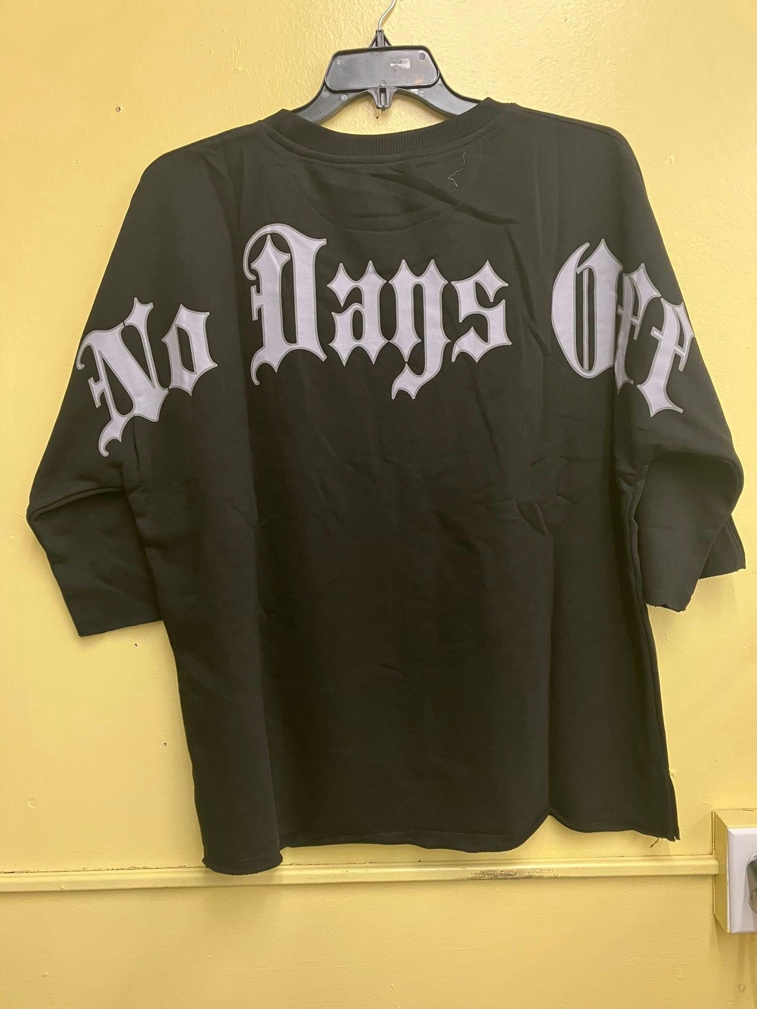 Black long-sleeve shirt on a hanger with "No Days Off" in white Old English-style lettering across the back.