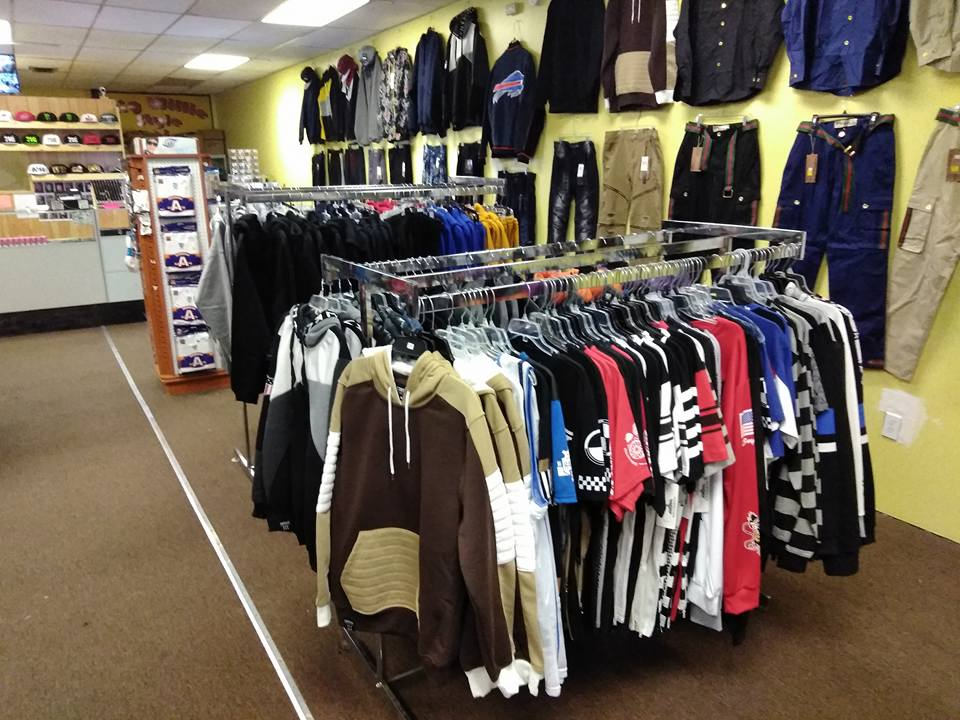 Clothing store with racks of hoodies and shirts, and wall displays of apparel, shoes, and hats.