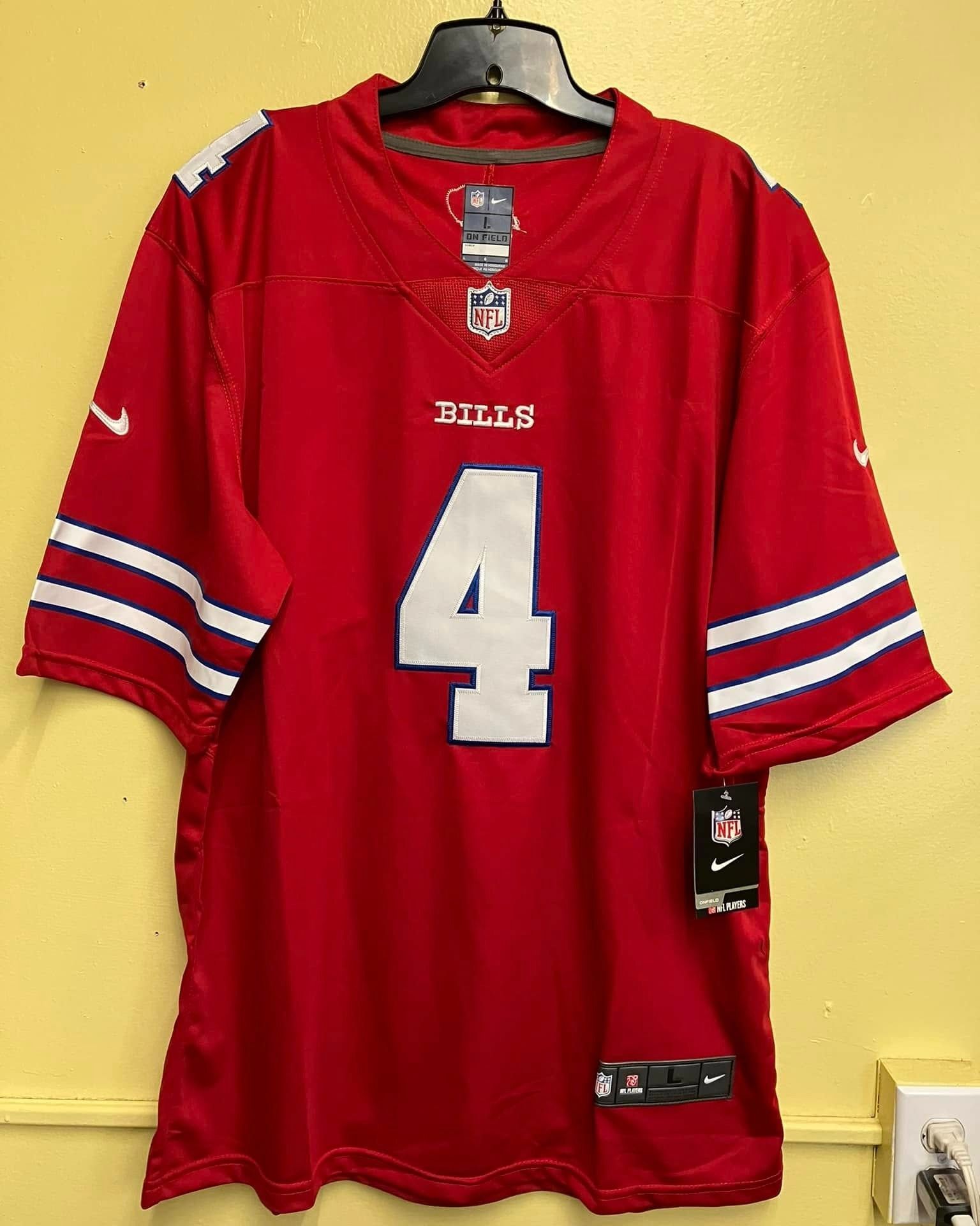 A red Buffalo Bills NFL jersey with the number 4 in white on the front, hanging on a hanger against a yellow wall.