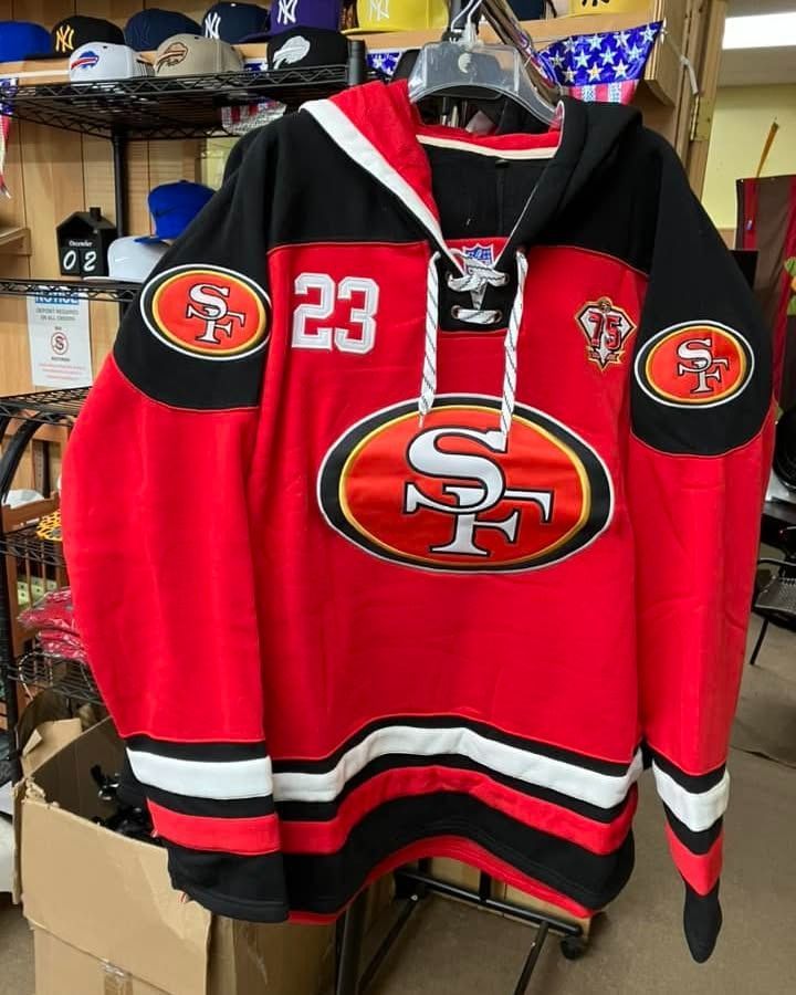 A red San Francisco 49ers hockey-style hooded sweatshirt featuring the team logo, the number 23, and black accents.