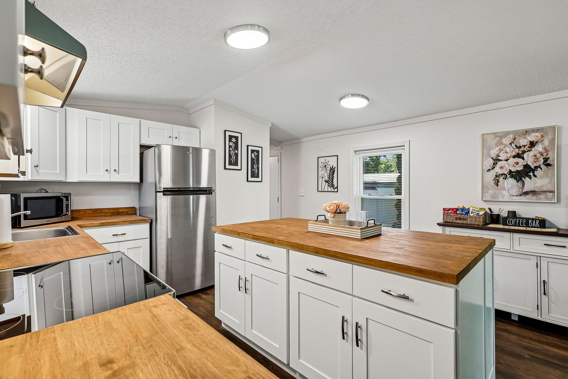 Modern kitchen featuring white cabinetry, center island, and stainless steel appliances.