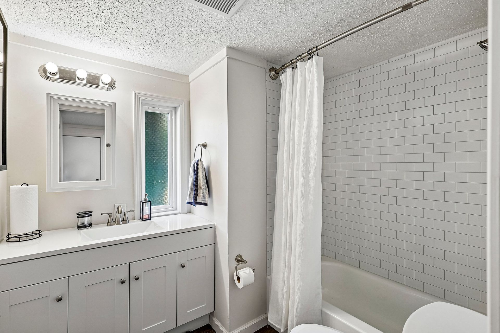 Updated bathroom with modern vanity, shower, and contemporary finishes.