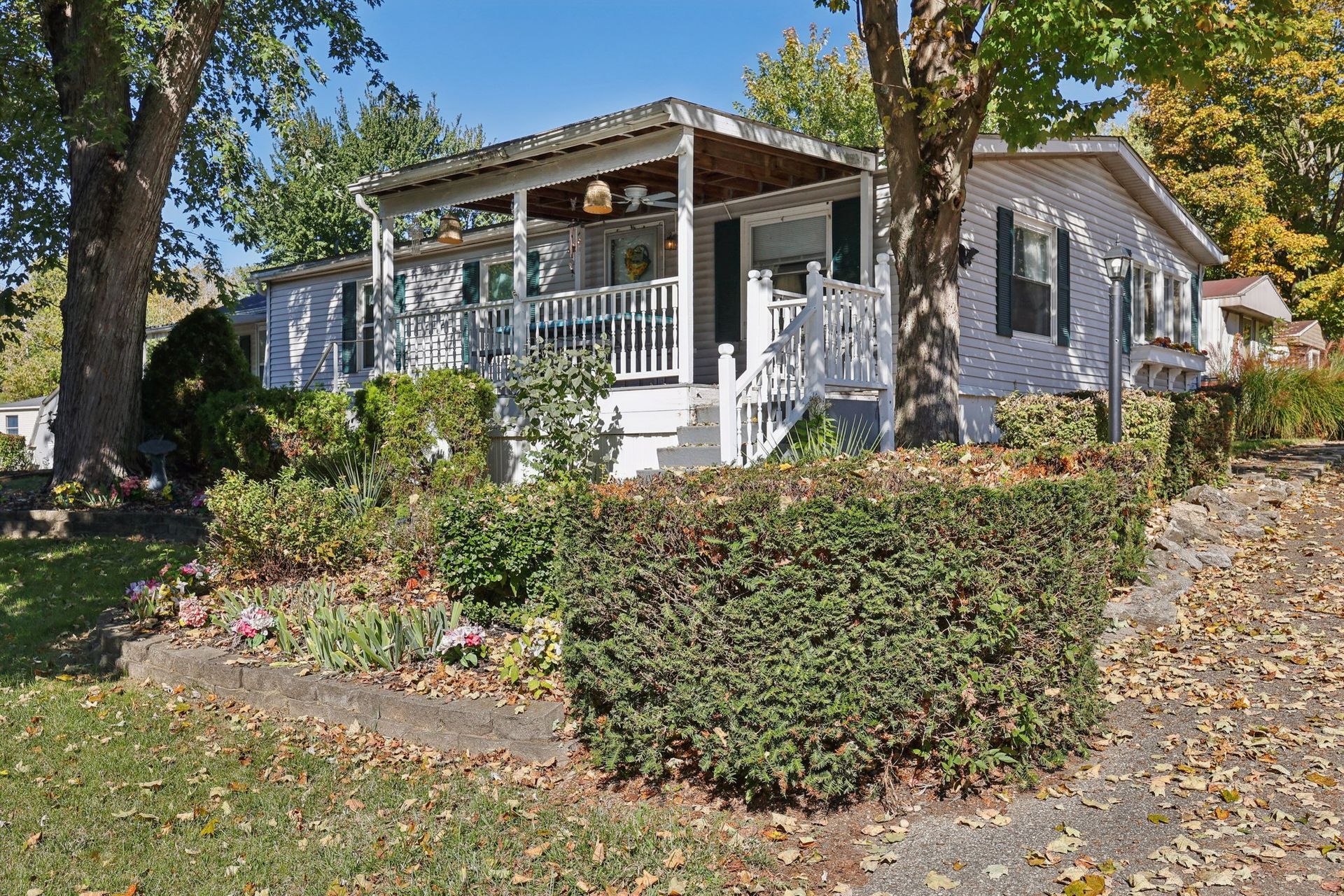 Beautiful manufactured home with covered front porch and landscaped yard.