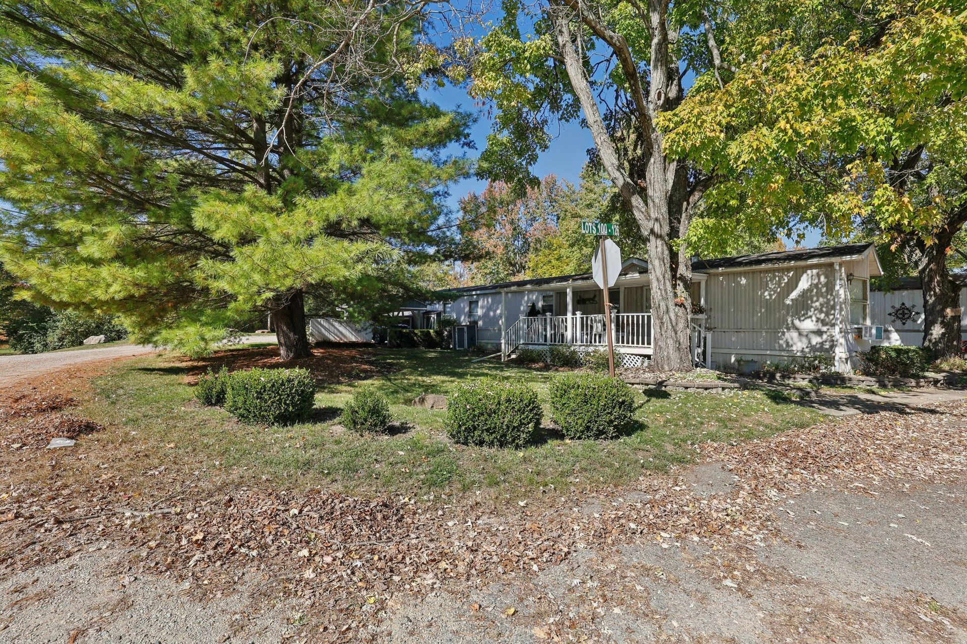 Manufactured home nestled among mature trees in a quiet neighborhood.