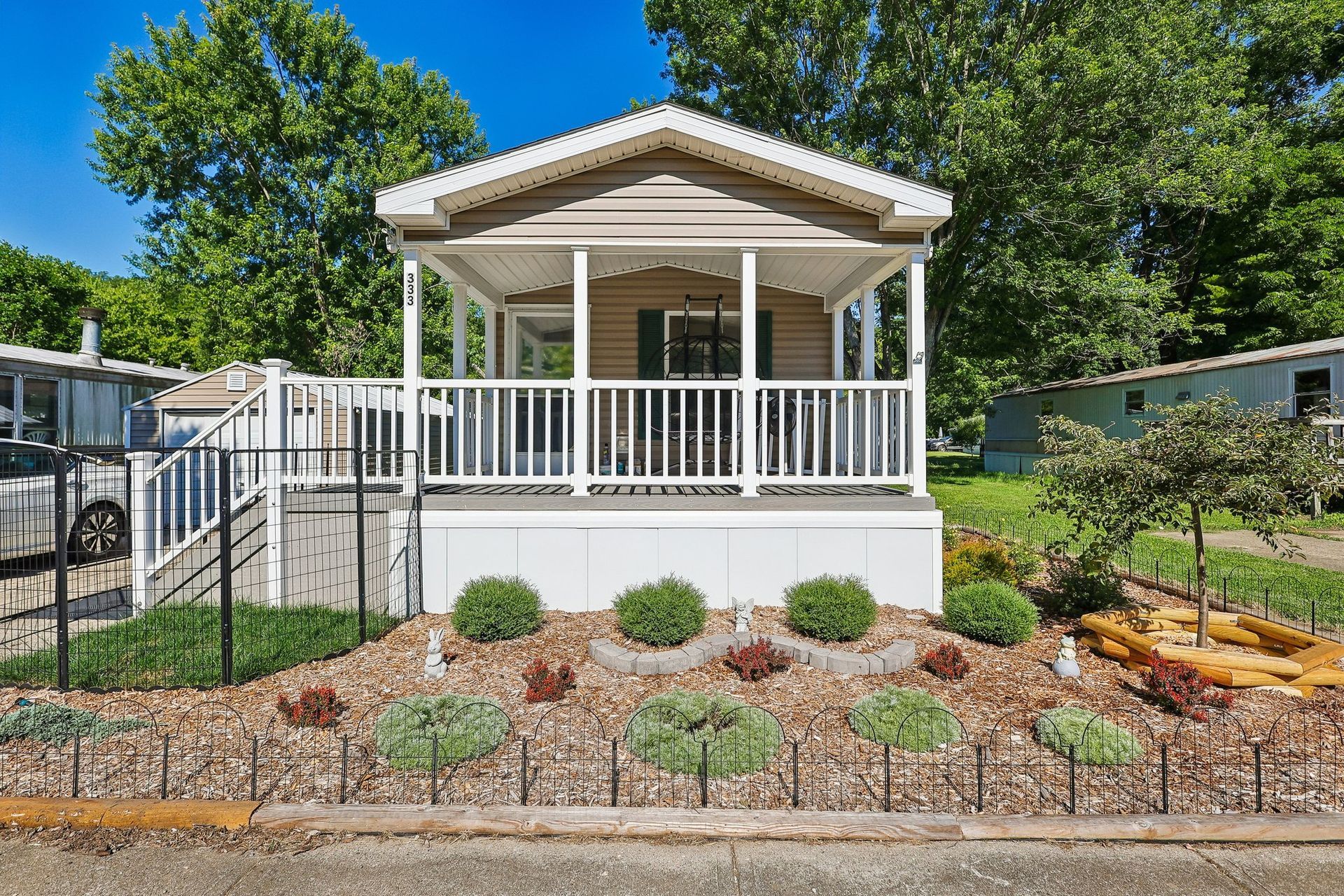 Manufactured home with covered porch and landscaped entrance.