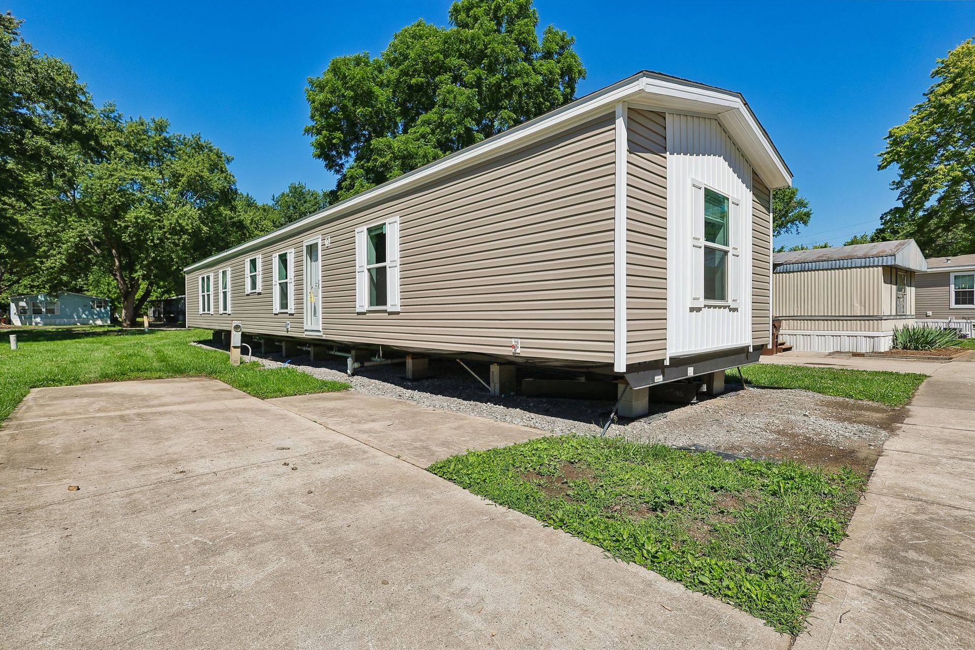New manufactured home with private driveway at Available Homes community.