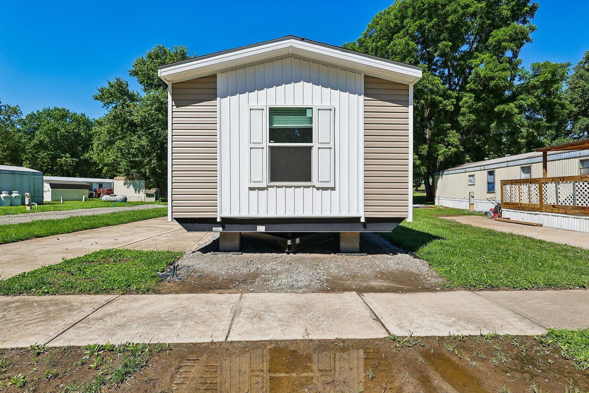 Front entrance of manufactured home with landscaped walkway.