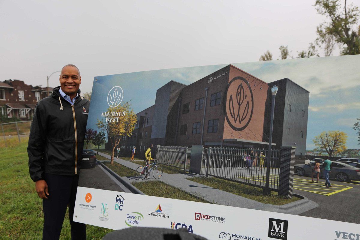 Dr. Troy Nash beside the Alumnus Gardens West rendering at the groundbreaking.