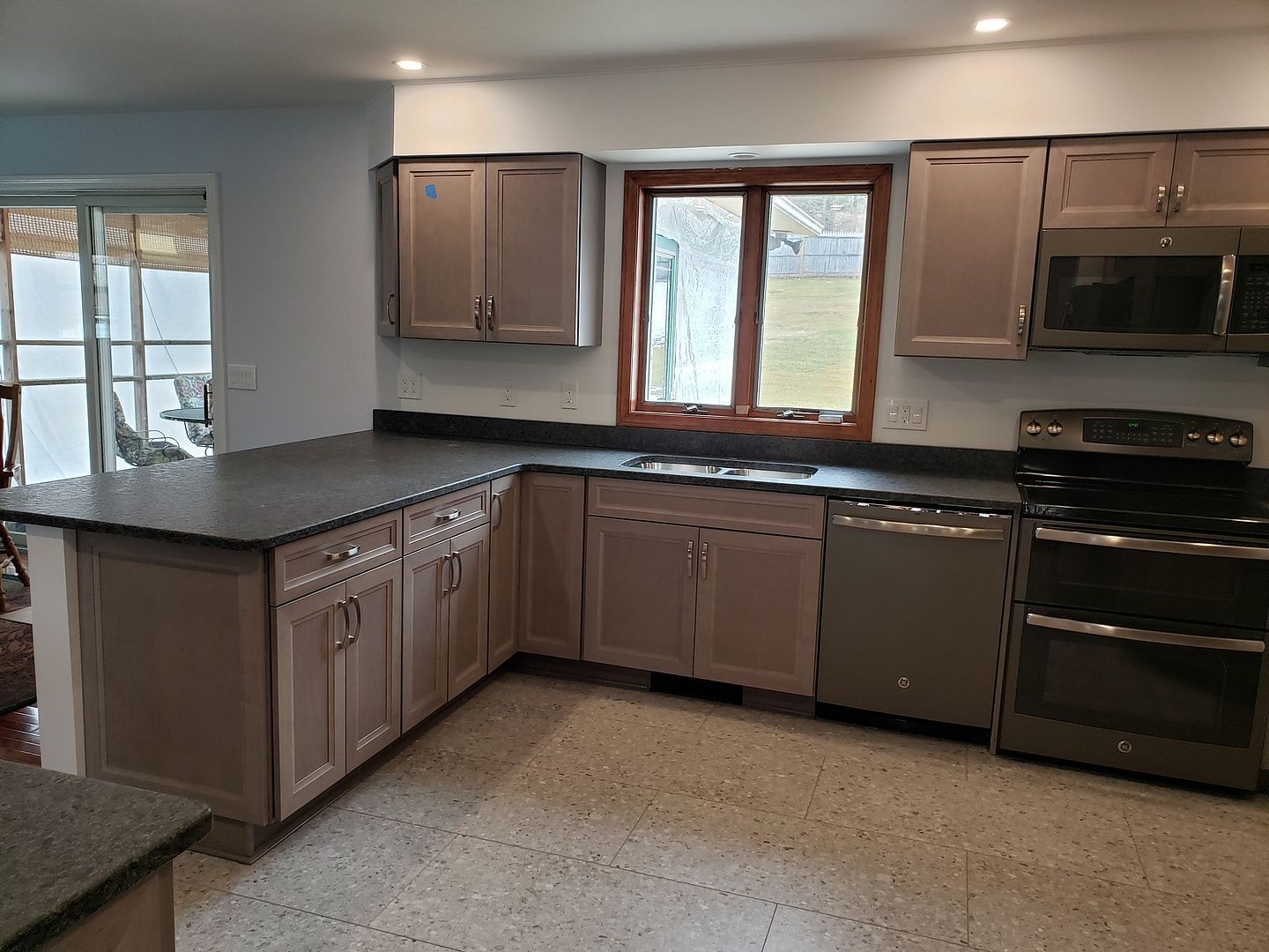 A kitchen with stainless steel appliances and granite counter tops.
