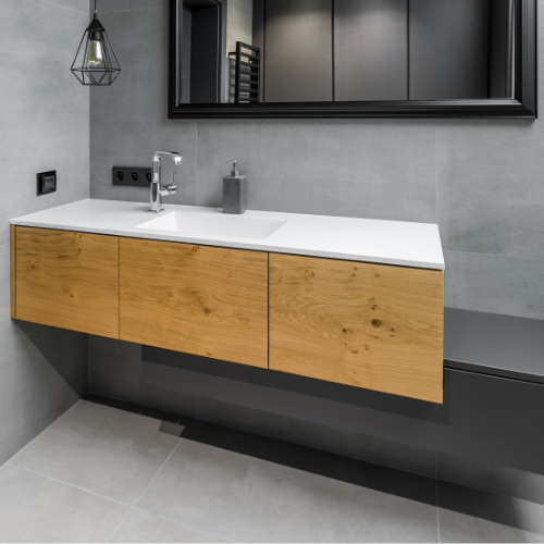 A bathroom with a sink , mirror and wooden cabinets