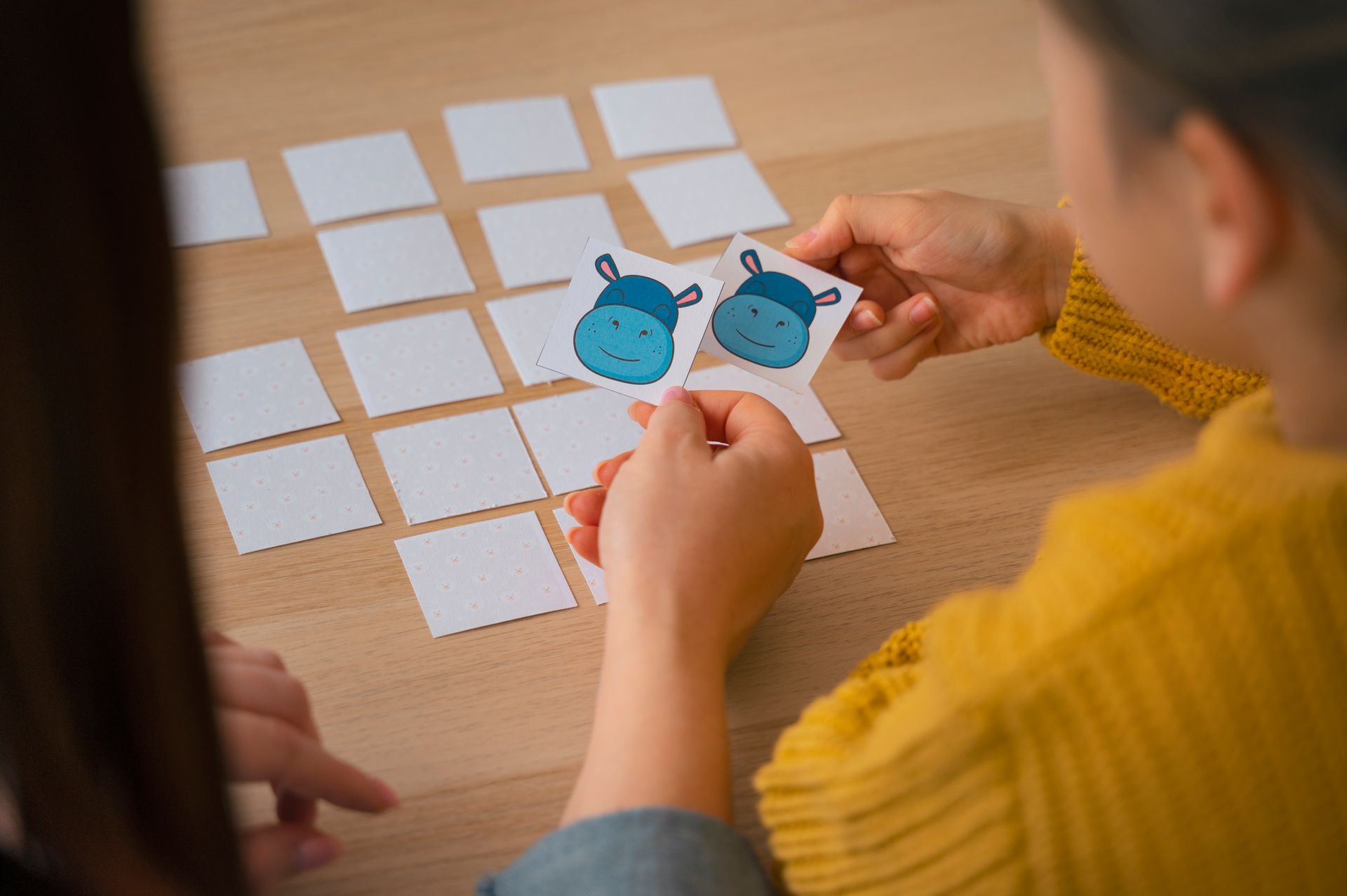 A woman is playing a game of memory with a child.